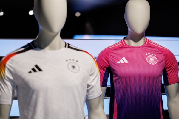 Wurde kontrovers diskutiert: die Farbwahl des neuen Pink und lilafarbenen Auswärtstrikots der deutschen Fußballnationalmannschaft (r). - © Daniel Karmann/dpa