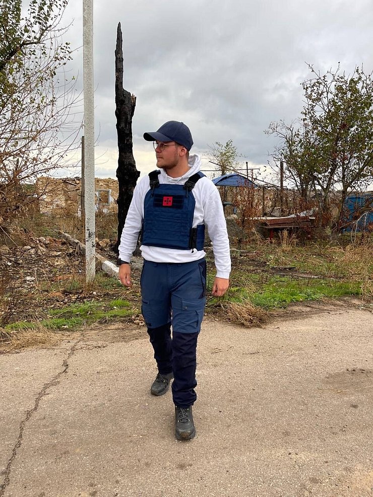 Jason Jochem mit einer schusssicheren Weste inmitten eines zerbombten Dorfes im Gebiet der südukrainischen Stadt Cherson. - © Jason Jochem