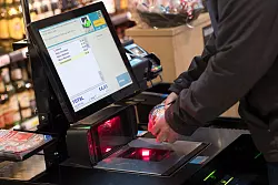 Ein Mann scannt in einem Supermarkt Lebensmittel an einer SB-Kasse. - &copy; picture alliance/dpa