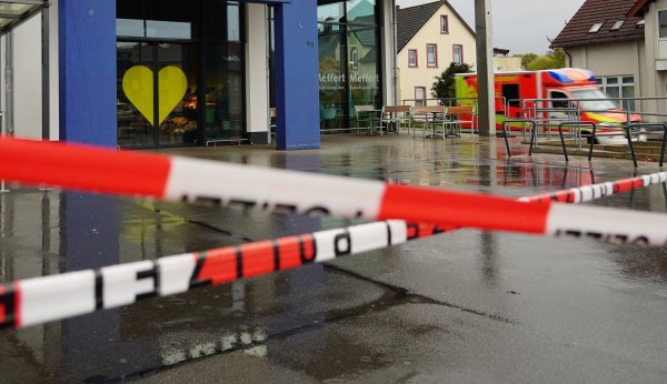 Die Polizei hat vor dem Supermarkt Absperrband angebracht, an der Seite steht ein Rettungswagen. - © Christian Müller/dpa
