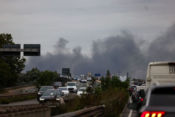 Eine Rauchwolke ist von der A59 aus zu sehen. - © Christoph Reichwein/dpa