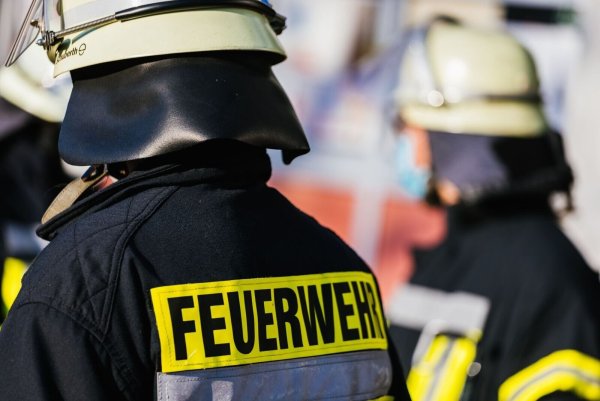 Einsatzkräfte der Feuerwehr in Schutzkleidung. - © Philipp von Ditfurth/dpa/Symbolbild