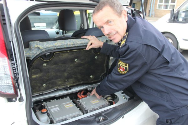 Motor im Kofferraum: Bernd Heißenberg, Branddirektor bei der Bielefelder Berufsfeuerwehr, zeigt den Motor eines Peugeot iOn, der im Heck verbaut ist. Besonders gefährlich für Retter sind jedoch die Akkus, die sich meist im Unterboden befinden. - © Franz Purucker