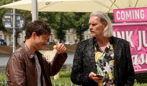 Götz Otto als Hotelinvestor David Brandt (r) unterhält sich mit einem Freund (Tobias van Dieken). - © Bernd Wüstneck/dpa