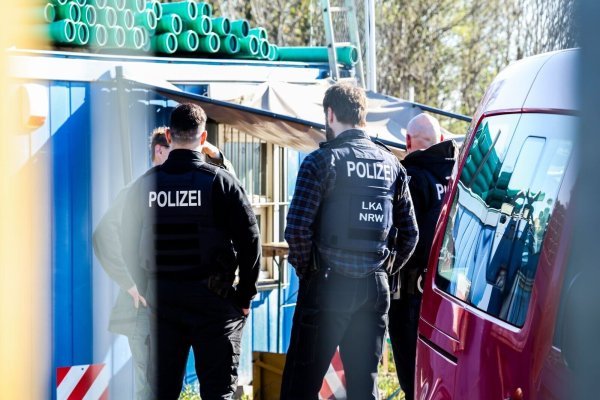 Polizeibeamte stehen auf dem Betriebsgelände einer Kiesgrube - © Christoph Reichwein/dpa