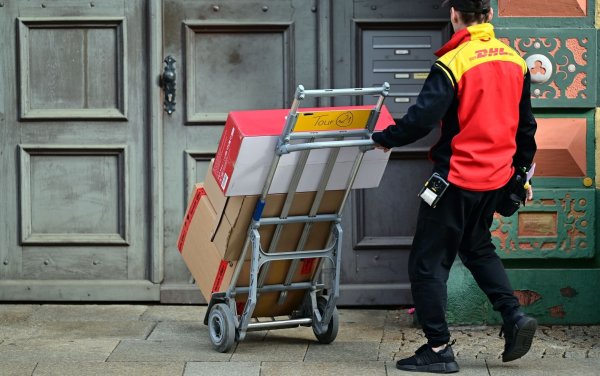 Klassische Briefe gibt es immer seltener. Doch dank des Online-Handels profitiert die Deutsche Post vom Paketversand. - © Martin Schutt/dpa