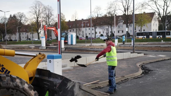 Der neue Parkplatz an der Hornschen Straße geht seiner Vollendung entgegen. Zu den letzten Arbeiten, die Marvin Mumot von der Bau-Union Lippe erledigt, gehört die Säuberung der Fahrbahnkanten von Asphaltresten - © Bernhard Preuss