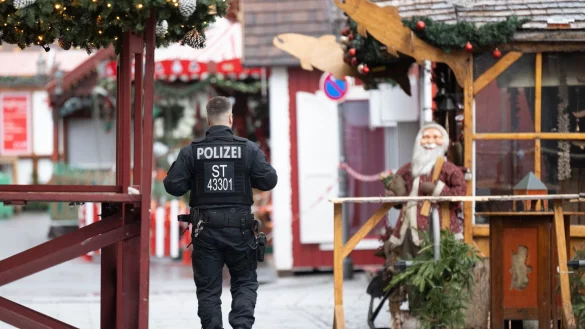 Ein Polizist geht über den gesperrten Weihnachtsmarkt. Am 20. Dezember 2024 ist auf dem Weihnachtsmarkt in Magdeburg ein Autofahrer in eine Menschengruppe gefahren. Es gab mehrere Tote und Verletzte. - © Sebastian Kahnert/dpa