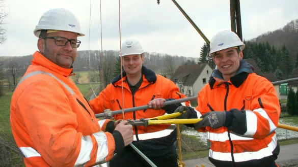 Die drei Landeseisenbahner Frank Muth (von links), der extra aus Brohl am Rhein zur LEL kommt, Adrian Fahrenkamp und Projektkoordinator Raphael Kahlert spannen den Fahrdraht auf.&nbsp; - &copy; Sylvia Frevert