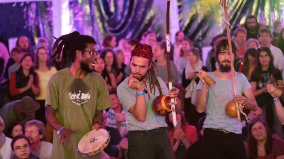 Mit Rhythmusgefühl: Capoeira-Workshop-Leiter Bobby Gomes (links) gibt den Takt vor und fordert die Besucher im Hauptzelt auf dem Yoga-Vidya-Gelände zum spontanen Mitmachen auf. - © Torben Gocke