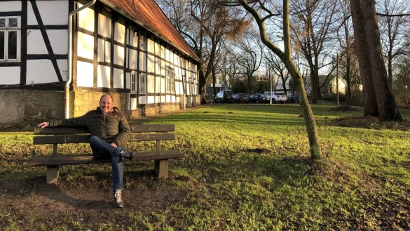 Hans-Joachim L&uuml;cking sitzt im Park mit den alten B&auml;umen am ehemaligen Jugendzentrum &bdquo;Das Haus" in Holzhausen. Das Areal k&ouml;nnte sich mit EU-Geldern zu einem Dorfmittelpunkt entwickeln. Daf&uuml;r will sich der Ortsausschussvorsitzende einsetzen. Foto: Thomas Reineke - &copy; Thomas Reineke