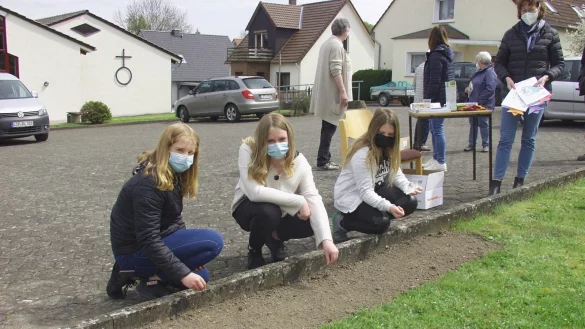 Die drei M&auml;dchen Charl&eacute;n, Mia und Malin s&auml;en die Blumensamen auf das Beet am Gemeindehaus in Varenholz. - &copy; Wulf Daneyko