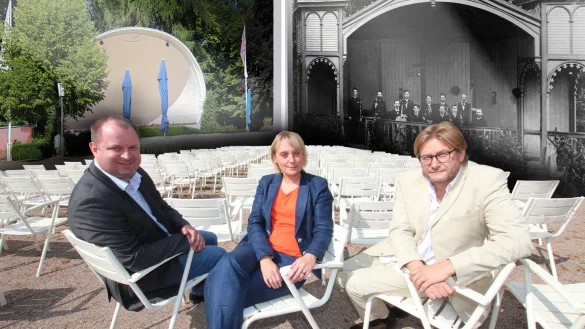 Früher und heute: Ludmilla Gutjahr (GesUndTourismus GmbH), Arne Brand (Landesverband, links) und Günter Weigel (Lippe Tourismus & Marketing) haben auf den Stühlen an der Musikmuschel Platz genommen. Im Hintergrund ist links das heutige Oval und rechts eine Aufnahme aus den Anfangszeiten zu sehen. - © Foto: Bernhard Preuss/Montage: Maren Brettmeier