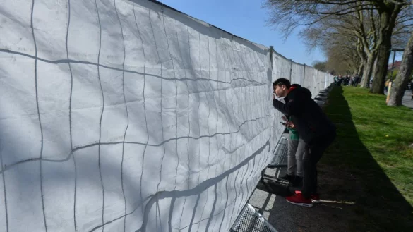 Symbolbild: Ein Junge schaut durch die Sichtabsperrung eines Zauns bei einem Fu&szlig;ballspiel. - &copy; picture alliance / dpa