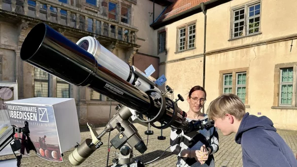 Einen gefahrlosen Blick auf die Sonne zu werfen, ist faszinierend. Bente Kähler (links), Leiter der Volkssternwarte Ubbedissen, erklärt dem 14-jährigen Julius, warum die Sonne Flecken hat. - © Weserrenaissance-Museum Schloss Brake