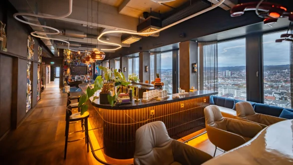 Spektakulärer Blick über Bielefeld, außergewöhliche Innenausstattung: Die Bar mit Loungebereich ist Mittelpunkt des großen Veranstaltungsbereichs in der 17. Etage des sanierten H1-Hochhauses. - © Sarah Jonek