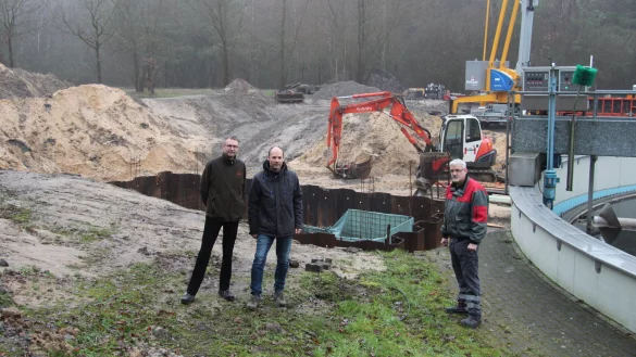 Armin Zimmermann, Dominik Klein und Abwasserleiter Oliver Rahlmeyer (von links) stehen auf der Baustelle an der Kläranlage. Rechts ist das Nachklärbecken zu sehen, im Hintergrund die Grube für den Reaktionsbehälter. - © Nadine Uphoff