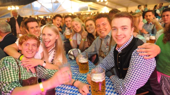 Zahlreiche G&auml;ste erscheinen in traditionellen Dirndl und Krachledernen im Festzelt. Dazu flie&szlig;t bayerisches Bier, und von der B&uuml;hne erklingt passende Musik. - &copy; Nicole Ellerbrake