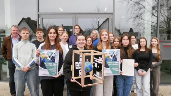 Sch&uuml;ler des Religionskurses der Q1 am Marianne-Weber-Gymnasium zeigen ihre preisgekr&ouml;nte Installation. Mit im Bild sind Andreas Mattke (links), Schulreferent der Lippischen Landeskirche, und Religionslehrerin Sandra Feringa-Lampe (hinten, Mitte). - &copy; Thomas Kr&uuml;gler