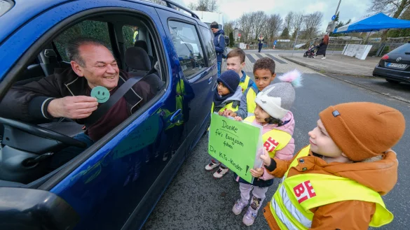 Zdenko Vidimovic bekommt von Noah, Arun, Mori, Imaan und Niko (von links) einen gr&uuml;nen Smiley. Danke f&uuml;r&rsquo;s langsam fahren. Die Kita-Kinder: F&uuml;r ihn holen sie das zweite Schild, das sie vorbereitet haben, heraus. - &copy; Andreas Zobe