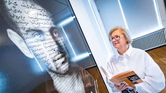Kuratorin Christiane Heuwinkel blickt auf Shirin Neshats Foto Ibrahim, in dem Bild und Schrift vereint sind. Foto: Sarah Jonek - &copy; Sarah Jonek Fotografie