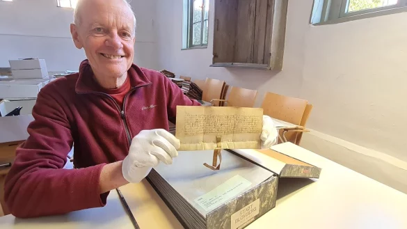 Kostbares Geburtstagskind: Dieter Zoremba zeigt die älteste erhaltene Urkunde des Stadtarchivs Blomberg. Der lippische Fürst Bernhard bestätigt dem just zerstörten Örtchen auf dem Blomberge seine Stadtrechte. - © Marianne Schwarzer