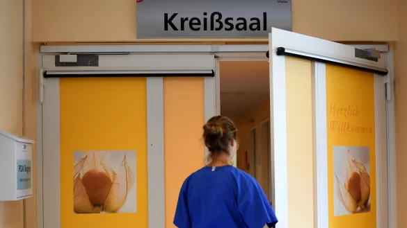 Eine Klinik-Mitarbeiterin steht vor dem Krei&szlig;saal. Die Aufkl&auml;rungsb&ouml;gen f&uuml;r eine m&ouml;gliche Schmerzhemmung durch Periduralan&auml;sthesie (PDA) werden links in den Postkasten eingeworfen. - &copy; Britta Pedersen/dpa