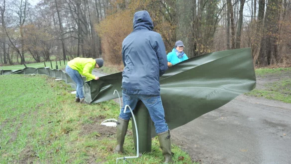 Mitglieder des BUND stellen bei b&ouml;igem Wind den Kr&ouml;tenzaun auf. - &copy; Claudia Viotto/ BUND Lage