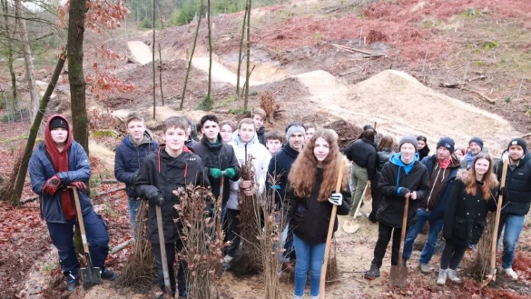 Mit Begeisterung machten sich die 30 Sch&uuml;lerinnen und Sch&uuml;ler der Klassen 9 und 10 ans Werk. Hinter ihnen sind die fast fertigen Mountainbike-Strecken zu erkennen. - &copy; Knut Dinter