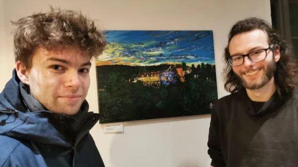 Stellt derzeit in den R&auml;umen der Burg Sternberg aus: der Lemgoer K&uuml;nstler Jonas J. Gr&ouml;ger (rechts) mit Julien Seck, dem Ideengeber f&uuml;r das Burg Sternberg-Bild im Hintergrund. - &copy; Sylvia Frevert