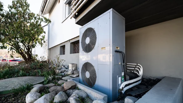 Die L&uuml;ftungsanlage einer W&auml;rmepumpe steht vor einem Wohnhaus. - &copy; Silas Stein/dpa
