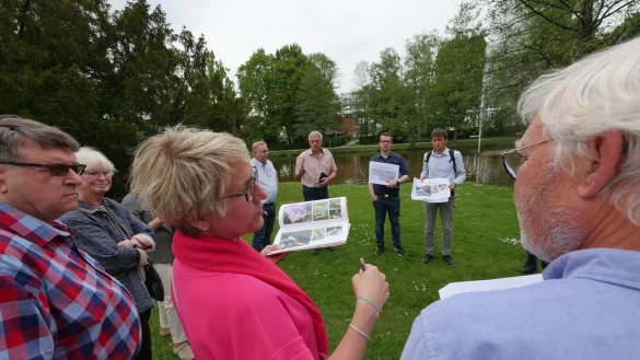 Diana Vorndamme, Vorsitzende des Vereins Bad Meinberg, erkl&auml;rt w&auml;hrend eines Rundgangs die Funktionsweise der Fitnessger&auml;te, die am Bad Meinberger Kurparksee platziert werden sollen. Im Hintergrund stehen (von links, mit Ausdrucken) Stadt-Pressesprecher Sebastian Vogt und Landschaftsarchitekt Matth&auml;us Janczyk. - &copy; Jost Wolf