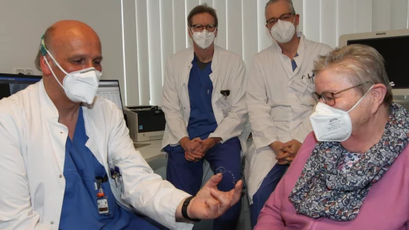 Oberarzt Dr. Dirk-Udo Härtel erklärt Erna Schweda, wie die Spange funktioniert, die nun dafür sorgt, dass ihre Herzklappe besser schließt. Oberarzt Dr. Johannes Brockmeyer (hinten links) und Chefarzt Dr. Stephan Gielen hören zu. - © Martin Hostert(LZ)