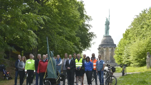Empfingen das XXL-Modell des &bdquo;Kantigen Hermanns" am Original des Denkmals in Detmold: D&ouml;rte Pieper (Stadt Detmold, 2. von links), Kurt Kalkreuter (Stellvertretend f&uuml;r Landrat Dr. Axel Lehmann, 6. von links), G&uuml;nter Weigel (Gesch&auml;ftsf&uuml;hrer der LTM, 8. von rechts), J&ouml;rg D&uuml;ning-Gast (Verbandsvorsteher des Landesverbands Lippe, 7. von rechts) mit der Delegation aus H&ouml;velhof, die begleitet wird von Hubert B&ouml;ddeker (Vorsitzender des Verkehrsvereins H&ouml;velhof, 3. von links), H&ouml;velhofs B&uuml;rgermeister Michael Berens (4. von links), Thomas Westhof (Wirtschaftsf&ouml;rderung und Marketing H&ouml;velhof, 6. von rechts) und Anja Veith (Gesch&auml;ftsf&uuml;hrerin Touristikzentrale Paderborner Land, 3. von rechts).&nbsp; - &copy; LTM GmbH