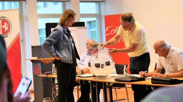 Kim Marie Kreilaus verfolgt gespannt, wie Bernhrad Brandt den Lostopf bef&uuml;llt. Die junge Dame vom VfL Lieme fungierte auf der Arbeitstagung des FuL-Kreises Lemgo als Gl&uuml;cksfee und zog die Lose f&uuml;r den Kreispokal. - &copy; J&ouml;rg Hagemann