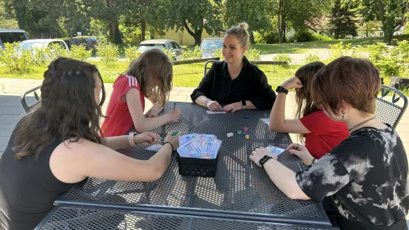 Teamleitung Tanika Gro&szlig;ehelleforth spielt mit einigen M&auml;dchen aus ihrer Wohngruppe auf der Terrasse ein Spiel. - &copy; Alexandra Schaller