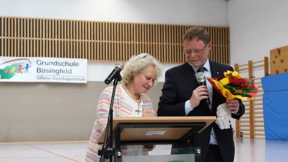 Mit ihrer Unterschrift ist es besiegelt: Silvia Genat verl&auml;sst nach 14 Jahren die Grundschule B&ouml;singfeld. Von Schulamtsdirektor Torsten Buncher gibt es ein Gru&szlig;wort und Blumen zum Dank. - &copy; Lorraine Brinkmann