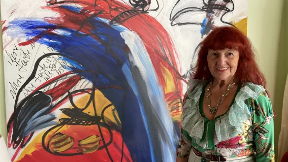 Heide Haike mit ihrem Lieblingsbild, das sie 2003 gemalt hat und das derzeit im Wohnzimmer h&auml;ngt. - &copy; Cordula Gr&ouml;ne