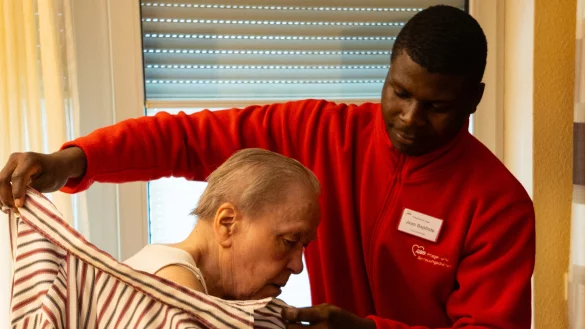 Bei der Arbeit: Jean-Baptiste Ongolo hilft Helga Schmaglowski beim Ankleiden. - &copy; R&uuml;diger Detering