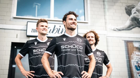 Die DSC-Profis Christopher Lannert (Mitte), Lukas Kunze (links) und Kapitän Mael Corboz haben das neue Auswärtstrikot angezogen. - © DSC Arminia Bielefeld
