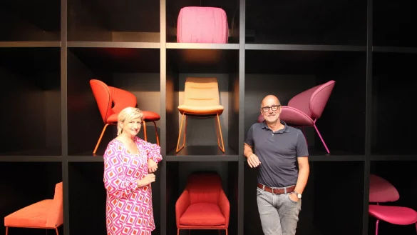 Gesch&auml;ftsf&uuml;hrer Jens Lewe und Finanzchefin B&auml;rbel Rodhorst stehen an einer Wand mit aktuellen KFF-M&ouml;belst&uuml;cken. - &copy; Jens Rademacher