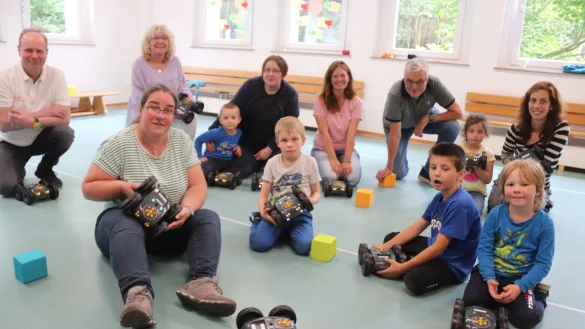 Was muss ich tun, um diese kleinen roboter&auml;hnlichen Fahrzeuge zu bewegen? Beim Workshop mit J&uuml;rgen St&uuml;kerj&uuml;rgen (hinten links) lernten Kinder und Eltern erste Schritte im Programmieren kennen. Foto: Knut Dinter - &copy; Knut Dinter
