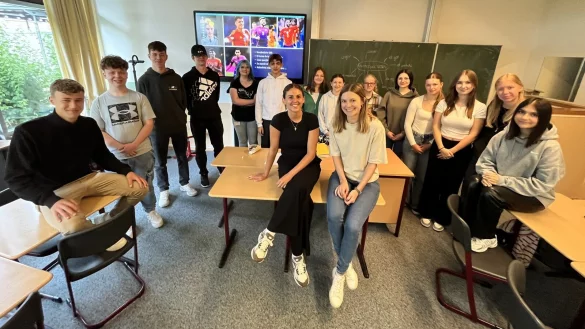 Die HSG-Linksau&szlig;en Ona Vegu&eacute; i Pena (sitzend, links) ist als Fremdsprachenassistentin der "Star im Klassenraum" am Hermann-V&ouml;chting-Gymnasium. Lehrerin Anna-Lena Christophery (rechts) freut sich ebenso wie die gesamte Klasse &uuml;ber ihren Einsatz. - &copy; Till Brand