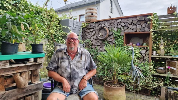 Timo Kampe sitzt an seinem Lieblingsort in Brake: seine Terrasse, auf der er unter anderem Chilis und Paprika (links) züchtet. - © Nadine Uphoff