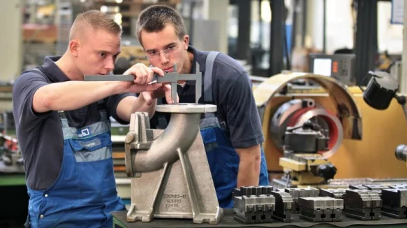 Ein Ausbilder zeigt einem angehenden Zerspanungsmechaniker, wie der Flanschkr&uuml;mmer funktioniert. - &copy; dpa