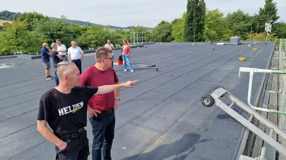 Hausmeister Dirk Frevert (vorne links) zeigt CDU-Ratsmitglied Olaf Copony das neue Dach der Grundschule Langenholzhausen. Ebenfalls dabei sind (hinten, von links) die SPD-Ratsmitglieder Manfred und Cornelia Rehse, Architekt Axel Bley, Bürgermeister Mario Hecker, Bauleiter Nikolai Stoll und Bauamtsleiterin Ewa Hermann. - © Nadine Uphoff