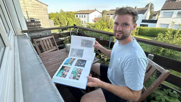 Sven Weedall sitzt auf dem kleinen Balkon seiner Wohnung und bl&auml;ttert durch sein Fotoalbum, das an seine Zeit in Gr&uuml;nau erinnert. - &copy; Alexandra Schaller