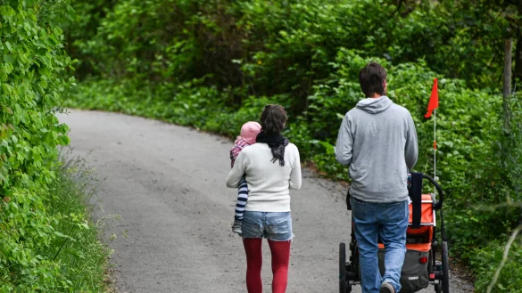 Ein Paar mit Kind l&auml;uft eine schmale Stra&szlig;e entlang. - &copy; picture alliance/dpa