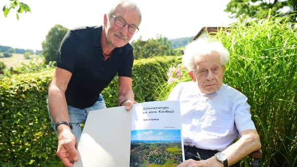 Rainer Dubbert (links), Vorsitzender des Heimat- und Zieglervereins Talle, zeigt das Buch von Gunter H&uuml;nerhoff (rechts). - &copy; Nicole Ellerbrake