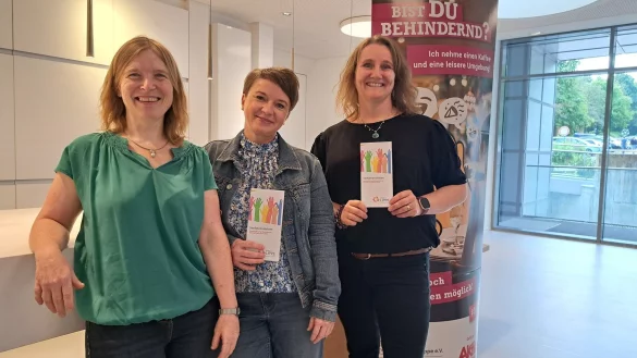 Simone Ackermann (Fachgebietsleitung Teilhabe und Netzwerke, von links) mit den Verfahrenslotsinnen Monika Heel und Sabine Hilkemeier im Kreishaus vor einem Aufsteller passend zur Arbeit. - &copy; Carolin Brokmann-F&ouml;rster